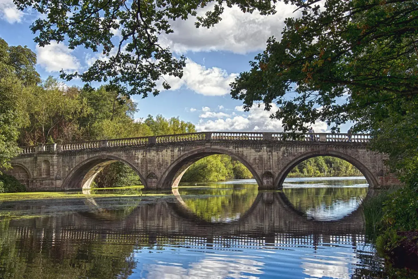 Steinbrücke über einen Fluss im Herbstlicht: Brücken überwinden Hindernisse und verbinden Menschen.